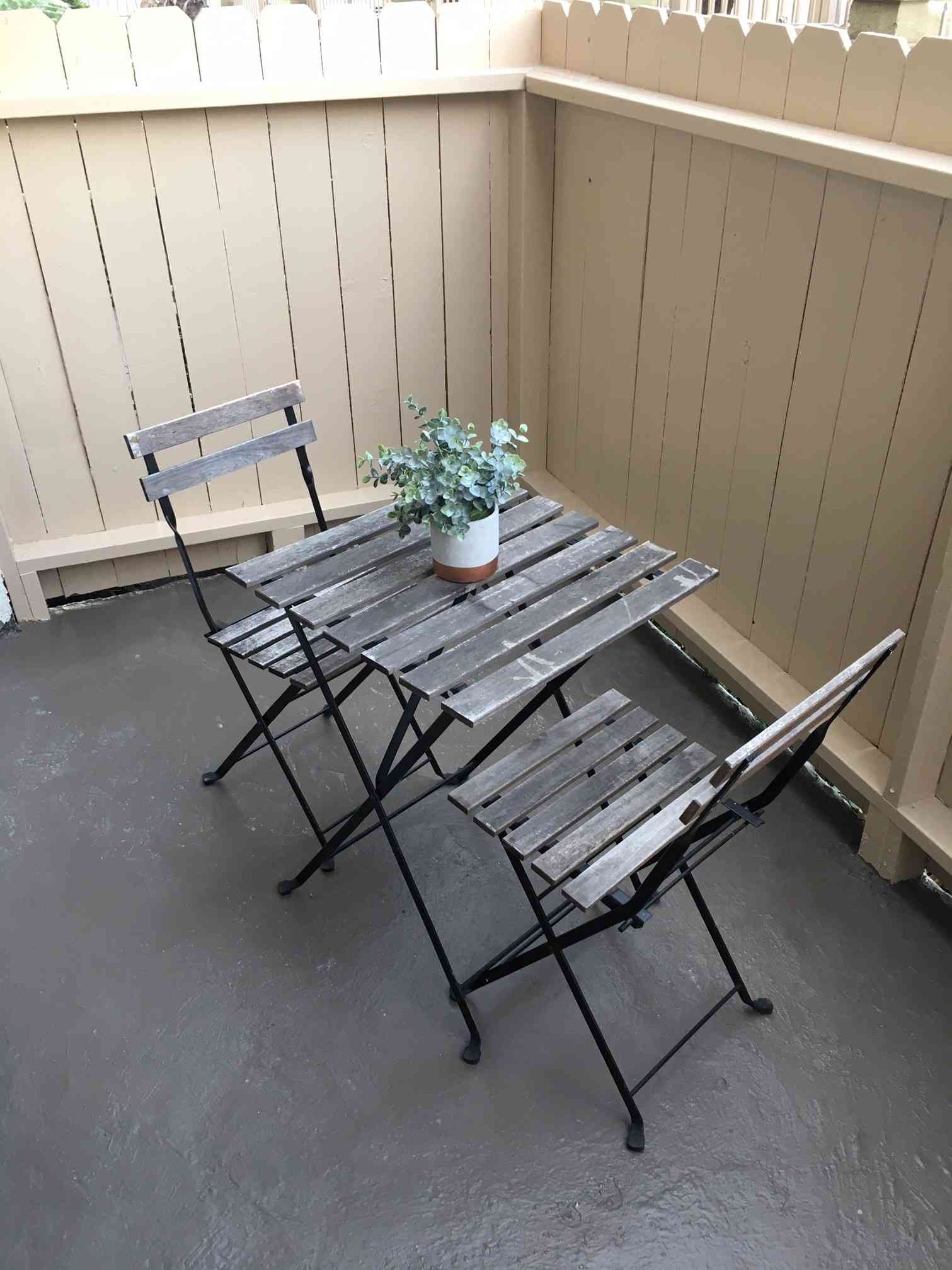 private patio bistro dining set with wood fencing