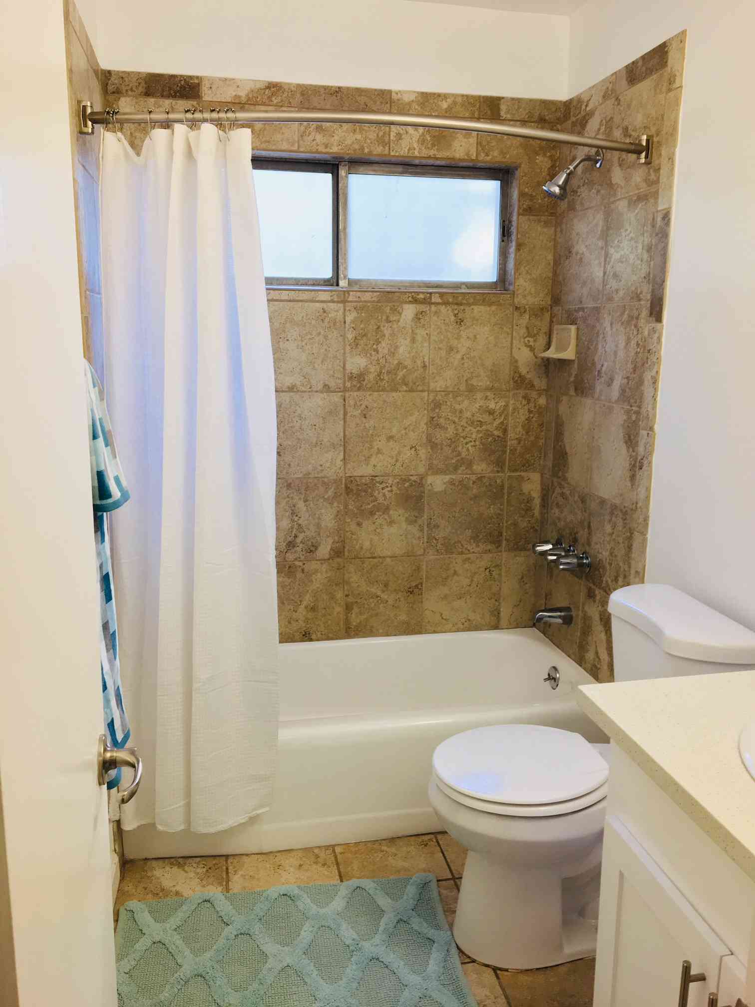 updated bathroom with earth tone tile shower